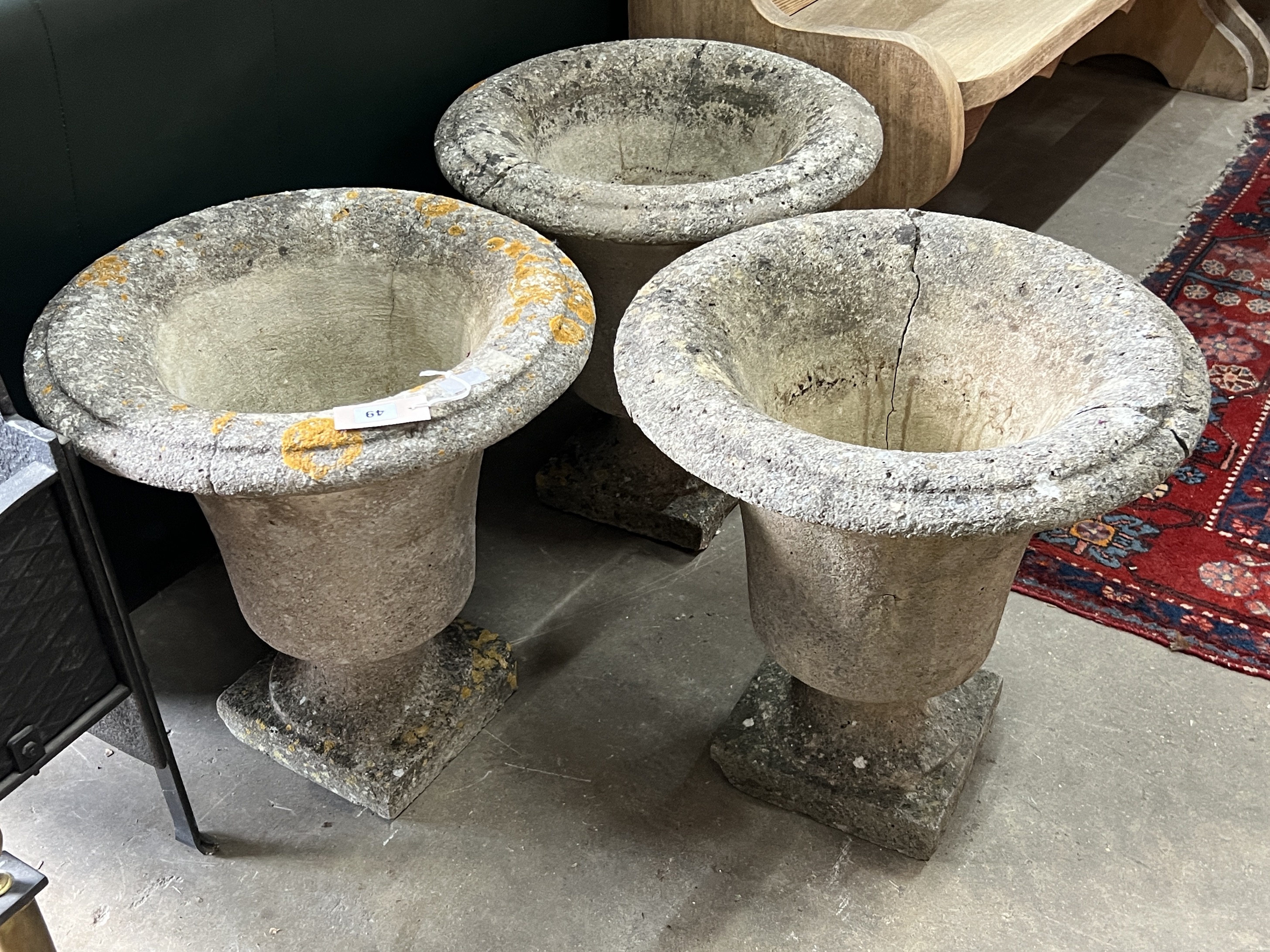 A set of three circular reconstituted stone garden urns, one cracked, diameter 48cm, height 50cm